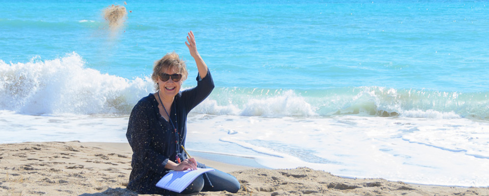 Carlota Baldrís, compositoria de la Suite de l'aigua Carlota Baldrís, a la sorra, amb el mar de fons treballant partitures